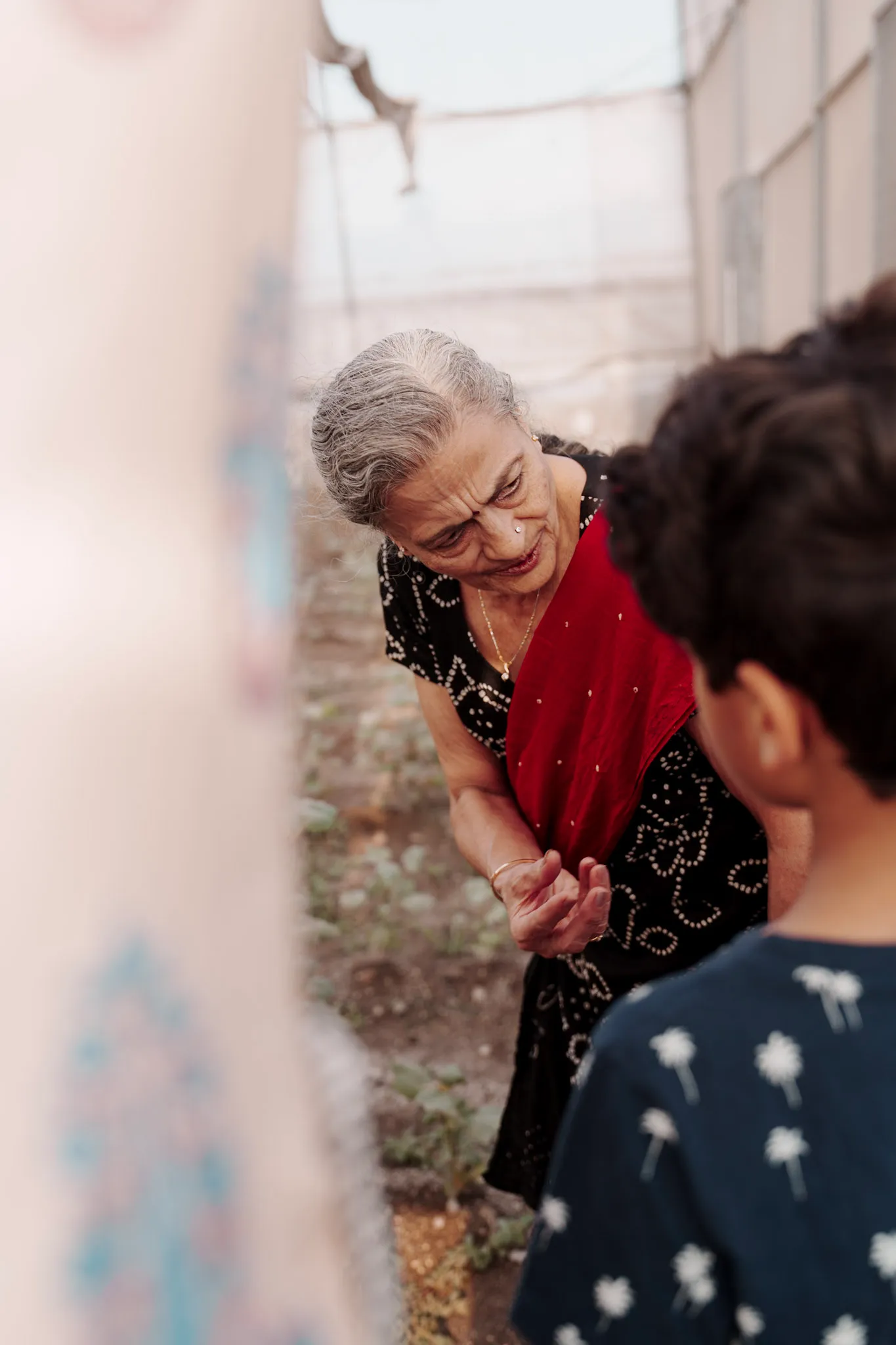 An elder woman leaning toward a child in conversation.
